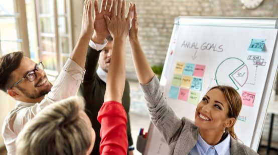 happy-business-team-with-raised-hands-celebrating-their-success-office_637285-7056