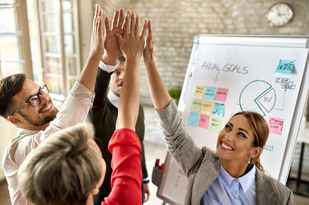 happy-business-team-with-raised-hands-celebrating-their-success-office_637285-7056